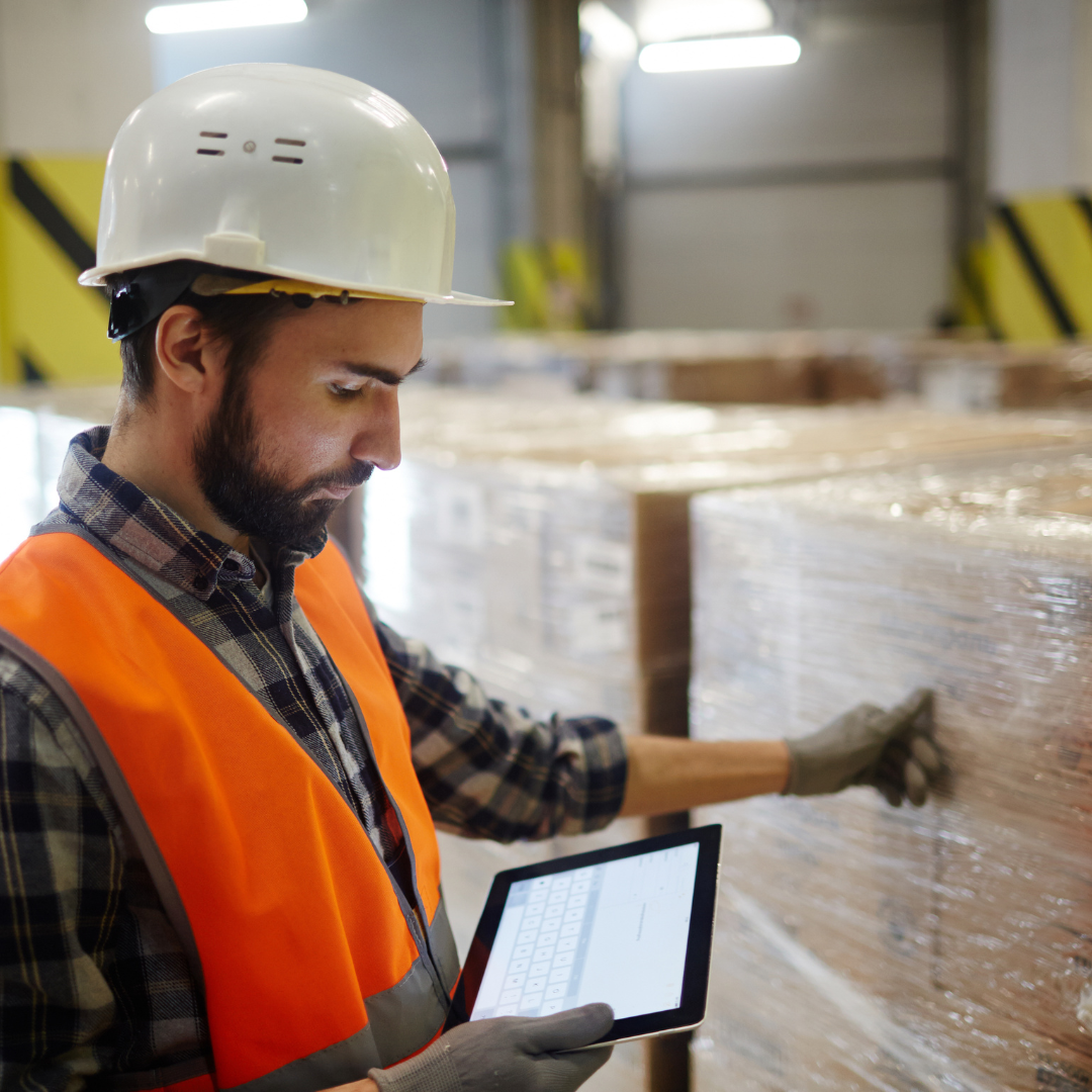 Logistikmitarbeiter prüft Palettenladung mit Tablet – Qualitätssicherung im Lager